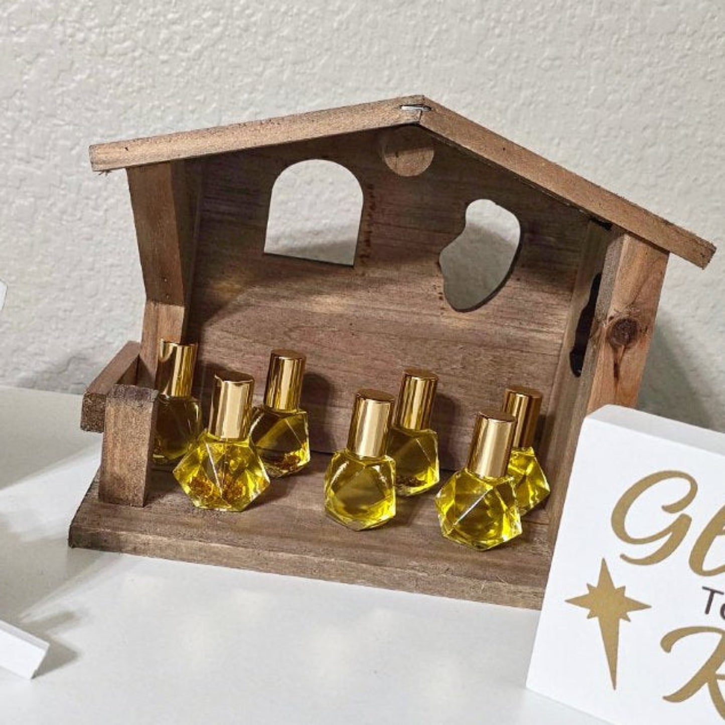 Exodus anointing oil blend in glass roller ball bottles displayed in a wooden stable.