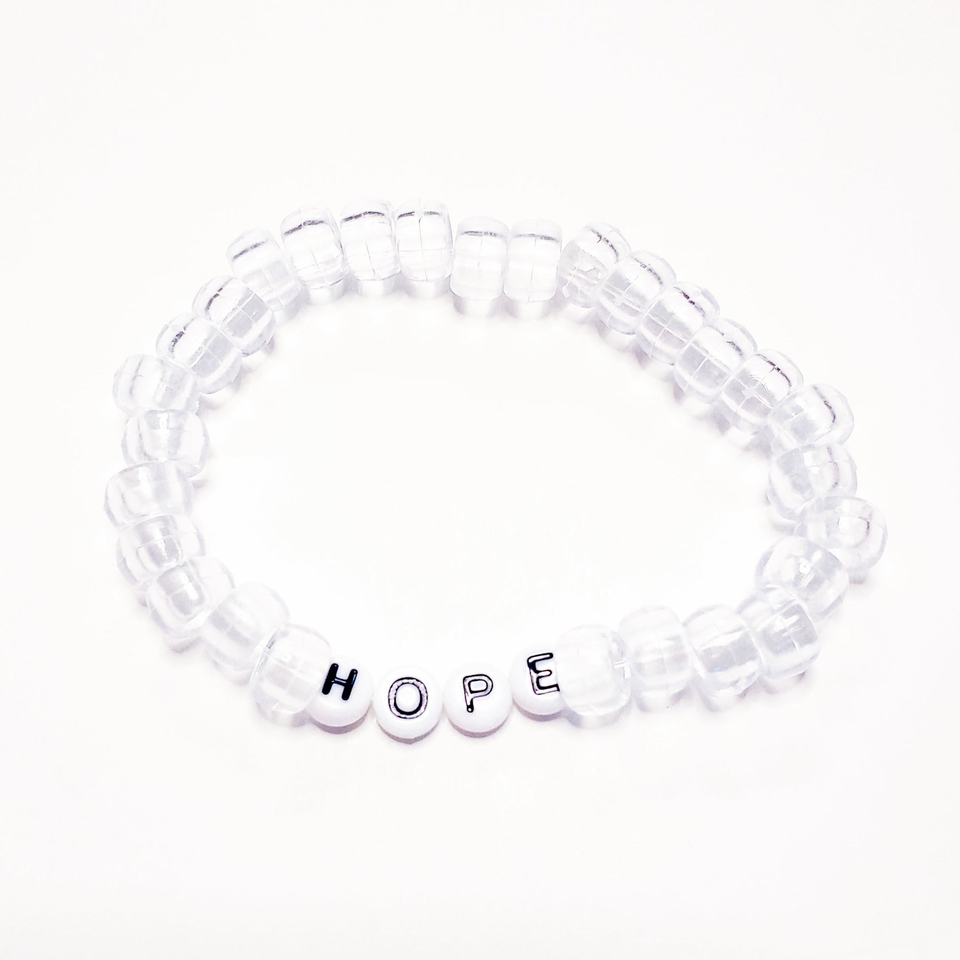Clear beaded bracelet with round white letter beads spelling HOPE in black letters