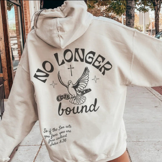 Back view of woman wearing sand-colored No Longer Bound Christian hoodie featuring dove breaking chains design with John 8:36 scripture verse