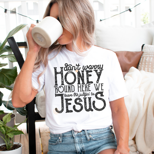Woman wearing white Don't Worry Honey statement tee with coffee mug in bright home setting