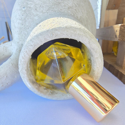 Exodus anointing oil blend in a roller ball glass bottle with a gold cap displayed in a white clay vase